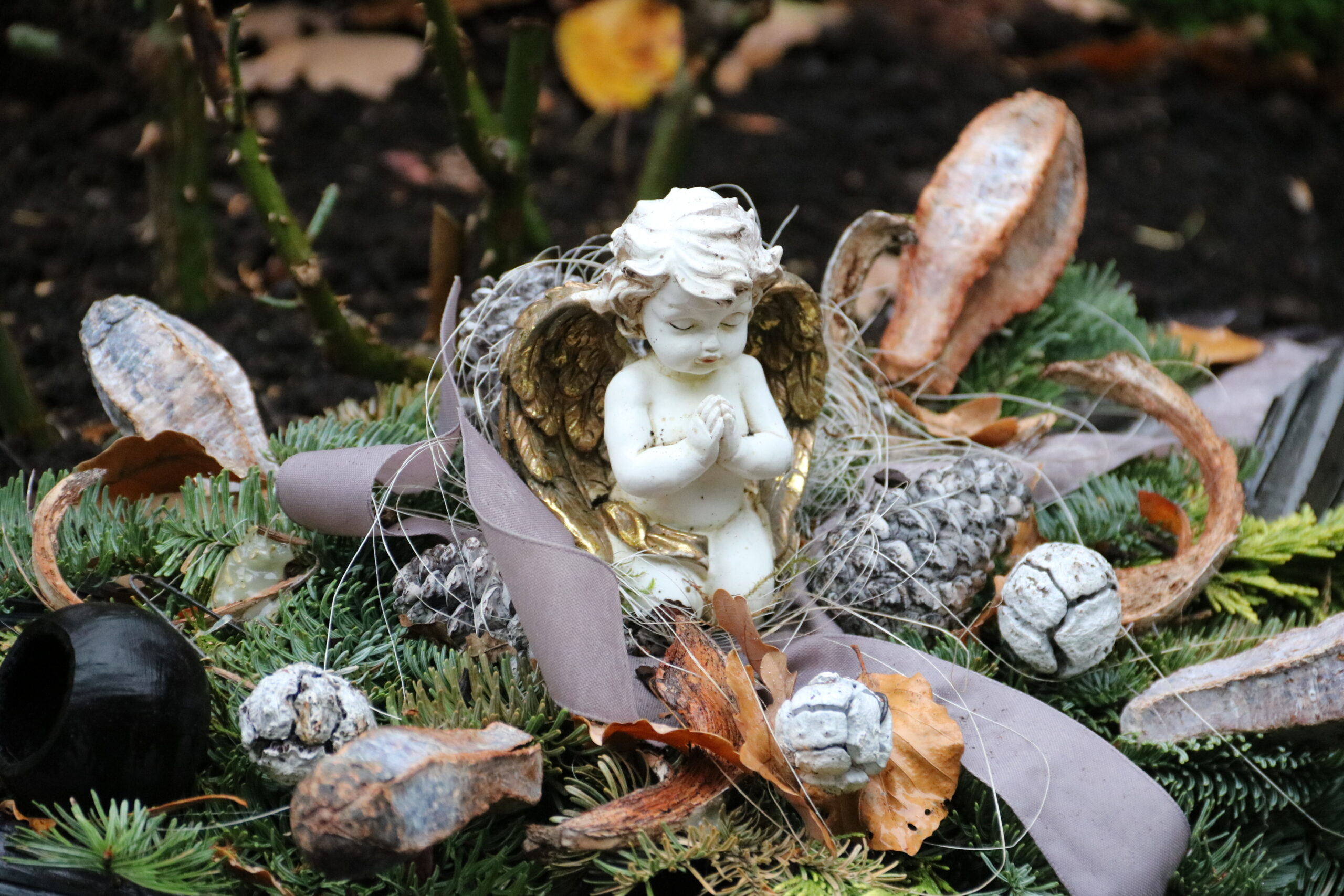 Grabschmuck mit Engel im Herbst auf dem Friedhof